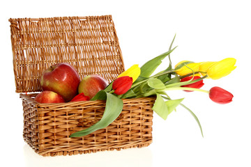 wicker basket of apples and flowers on a white background