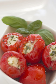 Spicy round red peppers stuffed with cheese in the white bowl.
