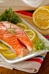 Fresh salmon steak with lemon slice, coriandr and dill