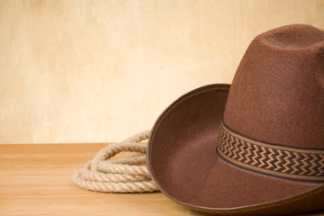 brown cowboy hat and rope on wood