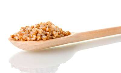 Wooden spoon with boiled buckwheat isolated on white