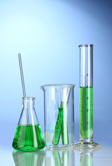 Laboratory glassware with green liquid with reflection