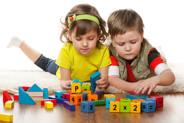 Two children are playing on the floor