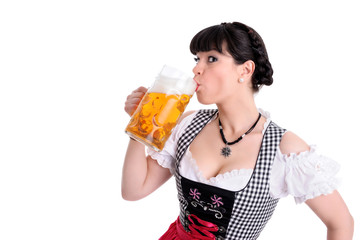 Junge Frau im Dirndl trinkt Bier