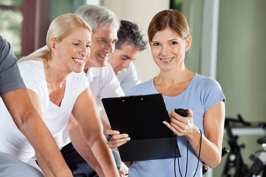 Fitnesstrainierin mit Klemmbrett und Stoppuhr