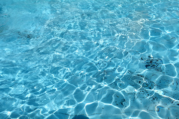 Background of rippled pattern of clean water in blue swimming po
