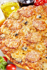 Italian cuisine. Pizza with salami, pickles and olives