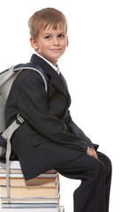 Schoolboy sitting on books