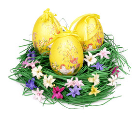 Three decorated easter eggs in the grass with hyacinth