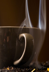 Filiżanka herbaty z dymiącymi liśćmi herbaty