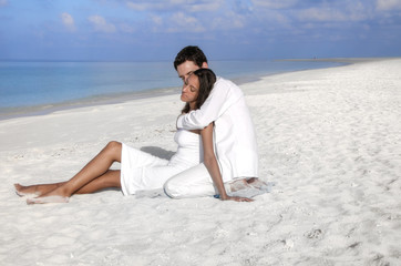 Fototapeta na wymiar Sensual happy lovers in white clothes on the beach (Maldives)