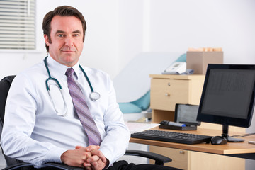 Portrait UK doctor sitting at desk