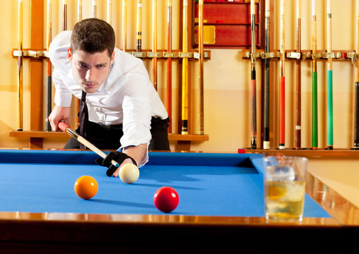 Billiard winner handsome man playing with cue and balls