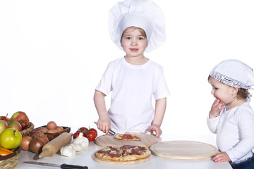 Zwei Mädchen kochen mit Kochmütze eine Pizza Porträt