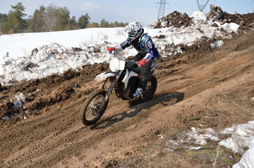 Fototapeta na wymiar Motocross athlete is accelerating on a sandy slope