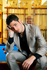 handsome man with suit sitting in billiard pool