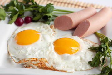 Traditional english breakfast food - fried eggs and sausages