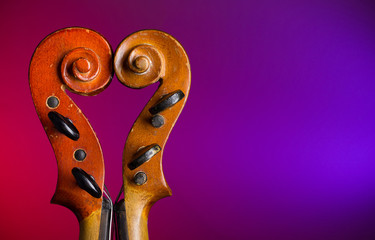 Two vintage violin scrolls make heart shape with copy-space