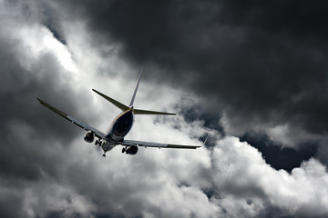 Fototapeta na wymiar Passenger jet landing against a stormy sky