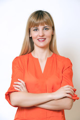Fototapeta premium Beautiful European young woman standing with her hands folded.
