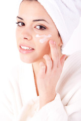 Young beautiful woman applying cream