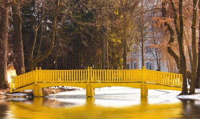 Spring landscape with yellow bridge over a lake