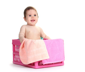 Cute baby girl sitting in laundry basket isolated on white