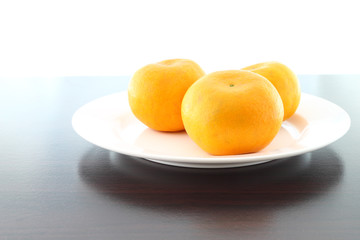 Three orange dish on wooden table.