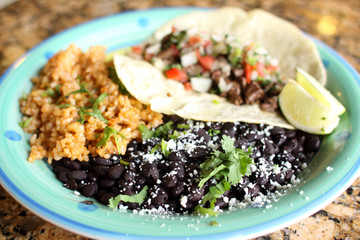 Steak soft taco with beans and rice.