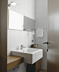 Fototapeta na wymiar szczegół białym ceramiczną umywalką z nowoczesną łazienką