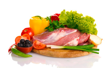 Raw meat and vegetables on a wooden board isolated on whitе