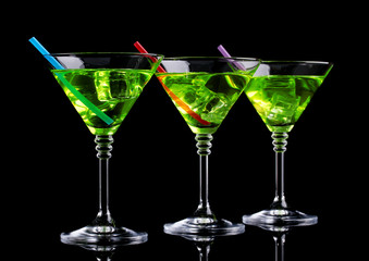 Yellow cocktail in martini glasses isolated on black
