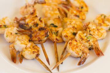 BBQ Prawns - Grilled prawn skewers on a white plate