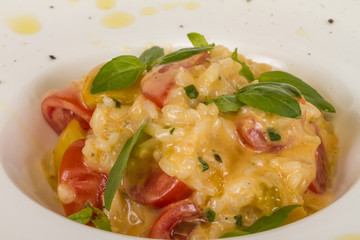 photo of delicious risotto dish with herbs and tomato on white b