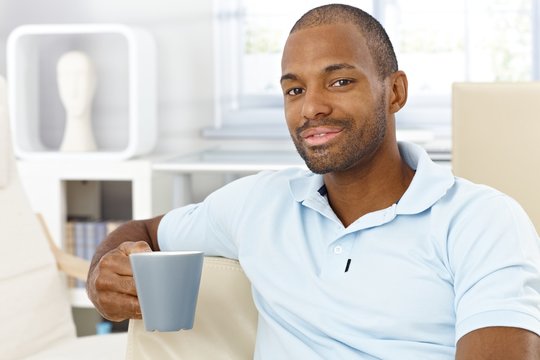Happy man having tea at home