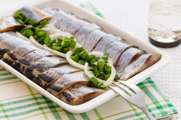 Portion of  herring fillets with herbs on the plate