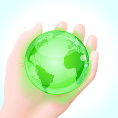 Human hand holding a green globe