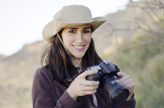 Young beautiful woman taking pictures in a hiking trip