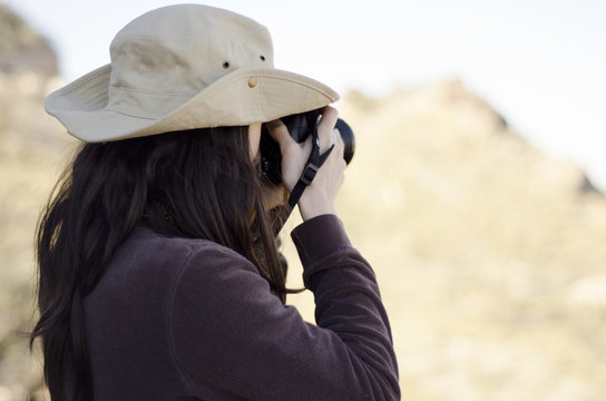 Young woman taking pictures of a view