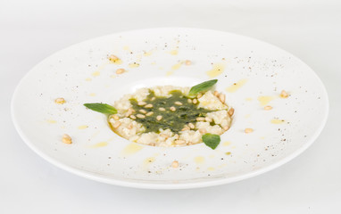 photo of delicious risotto dish with herbs and cedar nut on whit