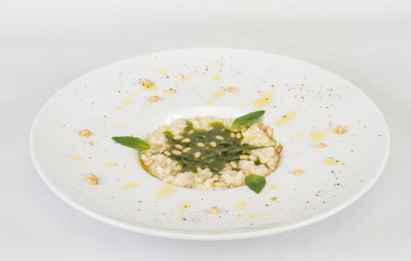 photo of delicious risotto dish with herbs and cedar nut on whit