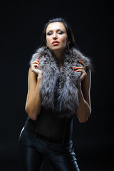 Image of glamorous woman wearing a fur. Dark background