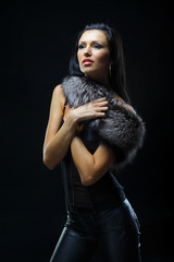 Image of glamorous woman wearing a fur. Dark background