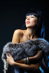 Beautiful woman covering the fur. Fashion art photo