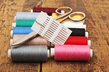 Colorful threads and old scissors on the old wooden table