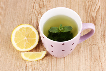 Mint tea with mint leaf and lemon on wooden background