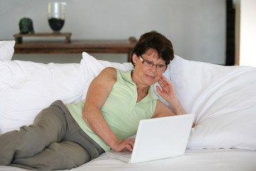 Mature woman using her laptop on a sofa