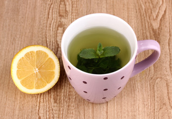 Mint tea with mint leaf and lemon on wooden background