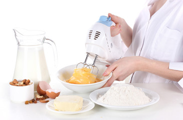 Female hands mixing eggs in bowl isolated on white