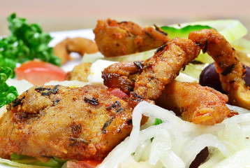 A meal of grilled meat and mixed salad on a plate
